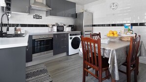 A modern kitchen with grey cabinets, a stainless steel refrigerator, a microwave, and a sink. - Holiday Home 'Casa Do Pacheco' with Sea View, Wi-Fi and Air Conditioning (Salga)