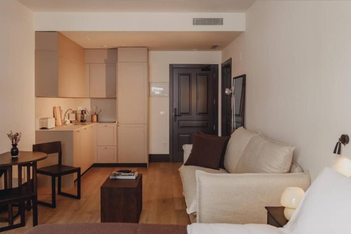 A compact living space with a kitchenette, a dining area, and a seating area with a sofa and a coffee table.