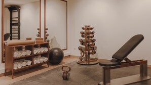 A gym with exercise equipment, a mirrored wall, and a relaxation chair. - Copla Bilbao (Bilbao)