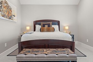 A bedroom with a large bed, two bedside tables, a bench, a painting, and a lamp. - Vista Moon: Cabin G - Pool, Chapel, Fire Pit (Fredericksburg)