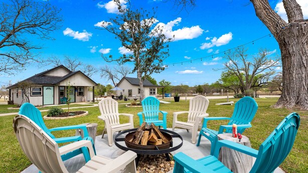 A patio with outdoor seating and a fire pit. - Vista Moon: Cabin D - Pool, Chapel, Fire Pit (Fredericksburg)