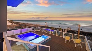 Un espace piscine offrant une vue sur la plage et l’océan.