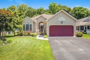 A single-story house with a red garage, a front porch, and a well-maintained lawn. - Lovely dog-friendly home with tennis, fast WiFi, deck, grill & W/D (Lewes)