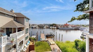 A waterfront property with a dock, a boat, and a marina in the background. - Town of Lewes condo steps from the park w/Tennis, Pickleball & Basketball (Lewes)