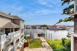 A waterfront property with a dock, a boat, and a marina in the background. - Town of Lewes condo steps from the park w/Tennis, Pickleball & Basketball (Lewes)