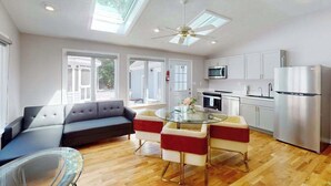 Une cuisine moderne avec un coin repas, de grandes fenêtres et un ventilateur de plafond.