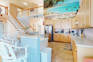 A kitchen with a central island, white chairs, a staircase, and a beach mural on the ceiling. - Swann Cove house with free WiFi and pool (Selbyville)