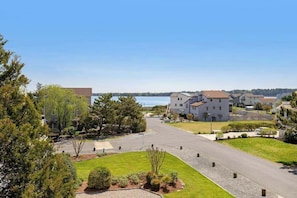 A residential area with houses, a road, and a body of water in the background. - Quillens Point home w/ 5 decks, screened porch, grill & shared tennis - dogs OK (Ocean View)