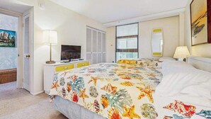 Une chambre d’hôtel équipée d’un lit, d’une télévision, d’un bureau et d’une fenêtre avec des stores.