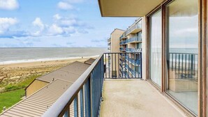 Un balcon avec vue sur la plage et l’océan.