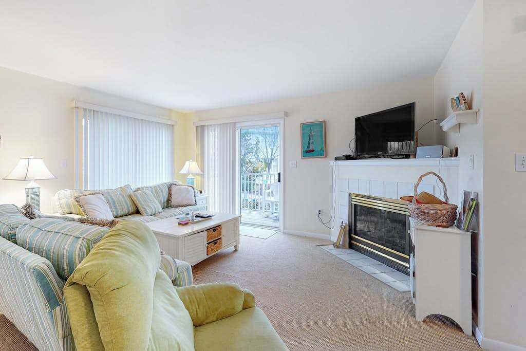A living room with a sofa, a coffee table, a fireplace, and a television.
