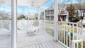 A covered porch with white railings, a ceiling fan, and two white lounge chairs. - Sea Colony Tennis 1st floor condo w/ shared pool, free WiFi, and balcony (Bethany Beach)
