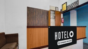 A hotel reception desk with a sign indicating it is a company-serviced hotel. - Saver Double Royapettah Clock Tower RKH (Chennai)