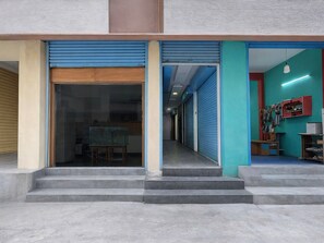 A building with a glass door entrance, a staircase leading to the entrance, and a hallway with closed shutters. - Saver Double Royapettah Clock Tower RKH (Chennai)