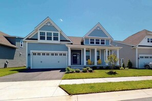 A residential house with a garage, a front porch, and a small lawn. - Millville by the sea home w/ shared pool, WiFi, central AC, W/D, & gas fireplace (Millville)