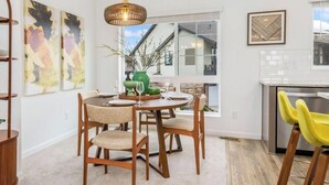 Un espace repas comprenant une table ronde, des chaises et une vue sur l’extérieur.
