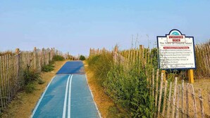 A beach path with a sign indicating it is unguarded, leading to the beach. - Town of Fenwick Island condo with dazzling sunrise views (Fenwick Island)