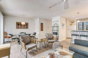 Ein modernes Wohnzimmer mit Essbereich, einer Küche und Blick ins Freie.