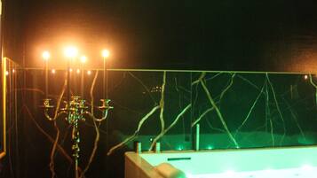 Una habitación con poca luz, una bañera, un soporte con luces y una pared con un diseño de grietas.