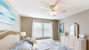 A bedroom with a bed, a dresser, a ceiling fan, and a window with blinds. - 2nd-floor condo at Bethany Bay with pool, on-site golf, and sports courts (Ocean View)