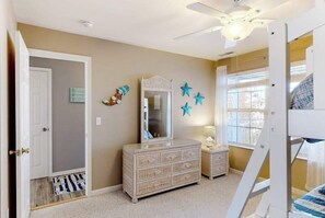 A child's bedroom with a bunk bed, dresser, mirror, star decorations, and a ceiling fan. - 2nd-floor condo at Bethany Bay with pool, on-site golf, and sports courts (Ocean View)