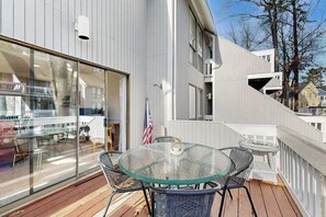A modern building with a glass balcony, outdoor seating, and a view of the surrounding area. - Sea Colony Tennis townhouse with pools, tennis, fitness centers, & private beach (Bethany Beach)
