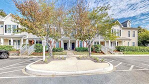 A two-story residential building with a front porch, a driveway, and a parking lot. - Bear Trap Dunes home w/ AC, fireplace, balcony, W/D, beach shuttle (Ocean View)