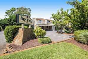 A sign for Sea Pines Village with a building in the background. - Sea Pines Village - Spectacular condo with W/D, gas grill, balcony, & pool (Bethany Beach)