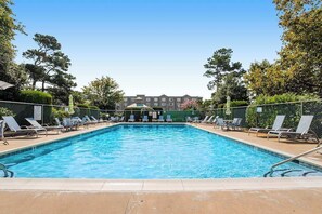 A rectangular swimming pool with a clear blue water surface, surrounded by lounge chairs and a fence. - Sea Pines Village - Spectacular condo with W/D, gas grill, balcony, & pool (Bethany Beach)