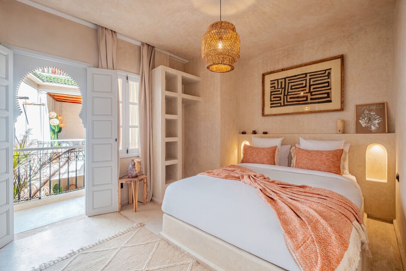 Un dormitorio con cama, lámpara colgante, estante en la pared y balcón con barandilla.