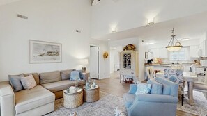 Ein geräumiges Wohnzimmer mit einer Couch, einem Couchtisch und einem Essbereich mit Tisch und Stühlen.