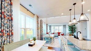 A spacious kitchen with a central island, a dining area with a bench, and a view of the outdoors. - Bishop's Landing townhouse with grill, outdoor pool, gym, tennis court, shuttle (Millville)