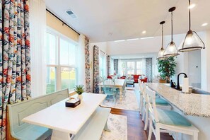A spacious kitchen with a central island, a dining area with a bench, and a view of the outdoors. - Bishop's Landing townhouse with grill, outdoor pool, gym, tennis court, shuttle (Millville)