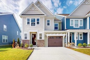 A two-story residential building with a garage, a covered entryway, and a well-maintained lawn. - Bishop's Landing townhouse with grill, outdoor pool, gym, tennis court, shuttle (Millville)