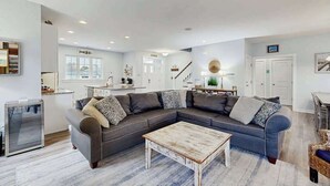 Ein modernes Wohnzimmer mit einer Eckcouch, einem Couchtisch und einem Essbereich.