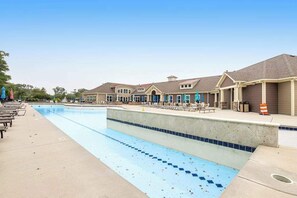 A swimming pool with lounge chairs and umbrellas, surrounded by buildings with a consistent architectural style. - Bishops Landing townhome with private washer/dryer, shared pool, tennis, gym (Millville)
