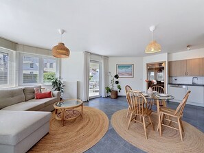 Eine moderne Wohnung mit Wohnzimmer, Essbereich und Küche.