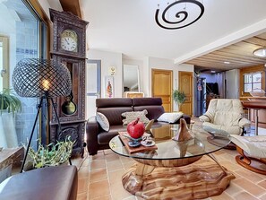 Ein Wohnzimmer mit einem braunen Ledersofa, einem Glastisch und einem Holznachttisch.