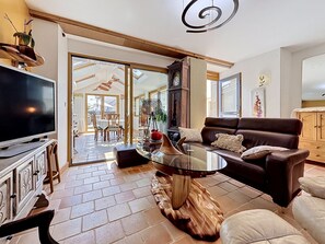 Ein Wohnzimmer mit Fernseher, Sofa, Couchtisch und Holzboden.