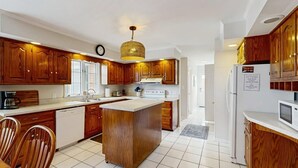 Une cuisine moderne avec des meubles en bois, un îlot central et un four à micro-ondes encastré.