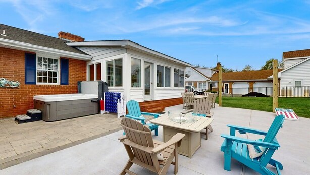 Un espace patio aménagé avec du mobilier d’extérieur, un jacuzzi et un coin salon abrité.