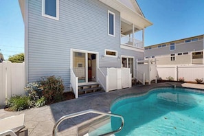A two-story house with a swimming pool, a balcony, and a covered patio area. - Spectacular pet friendly house walk to beach w/ocean views, private pool (Dewey Beach)