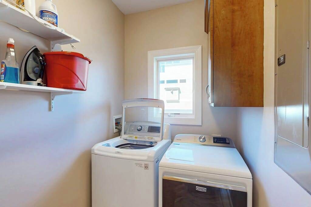 A laundry room with a washing machine, dryer, and a window.