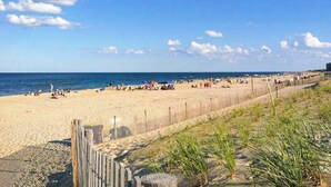A beach with a wooden fence, sandy beach, and the ocean. - Salt Meadows townhouse w/ elevator, gas fireplace & community pool and pier (Fenwick Island)