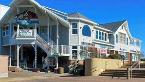 A coastal-style hotel with a balcony, a staircase, and a sign for a buffet. - Salt Meadows townhouse w/ elevator, gas fireplace & community pool and pier (Fenwick Island)