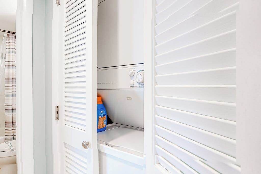 Una sala amb rentadora i ampolla de detergent.