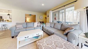 A living room with a sofa, a coffee table, and a patterned ottoman. - Sea Colony ground floor condo, updated with fast WiFi, gas fireplace, & deck (Bethany Beach)