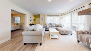 A spacious living room with a sofa set, a coffee table, and a patterned ottoman. - Sea Colony ground floor condo, updated with fast WiFi, gas fireplace, & deck (Bethany Beach)