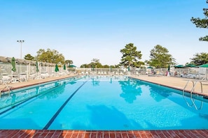 A swimming pool with lounge chairs and umbrellas, surrounded by a fence and trees. - Mallard Lakes Home w/Beautiful Water Views From Screened-In Porch, Shared Pool, WD (Selbyville)