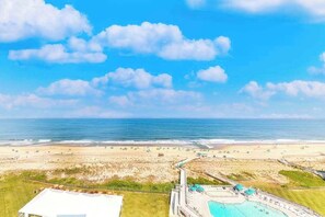 A beach resort with a swimming pool, beach access, and a view of the ocean. - Stunning beachfront condo with pool, sauna, balcony, W/D (Bethany Beach)